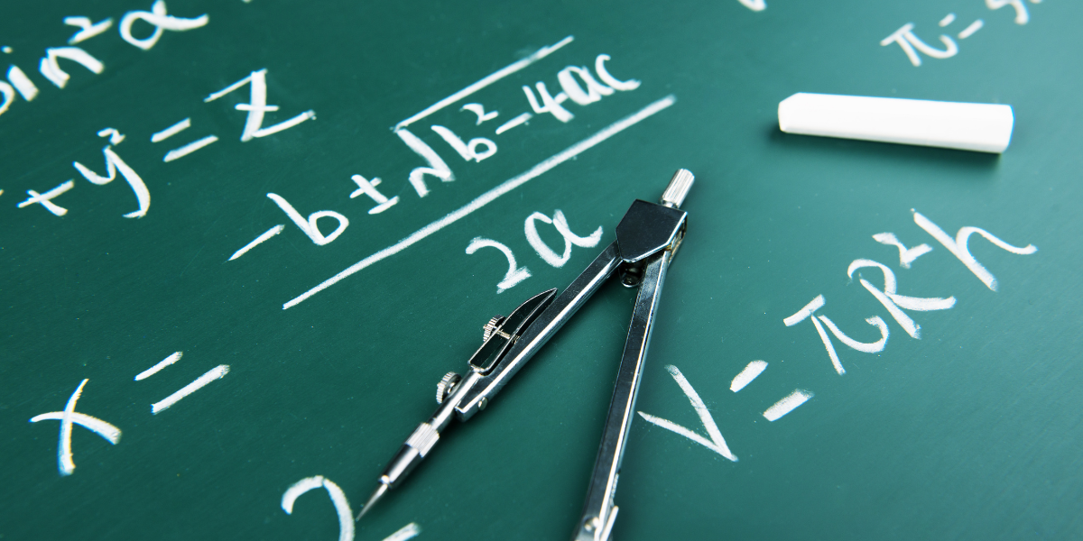 A student working through A-Level Maths problems at a desk with textbooks and notes open