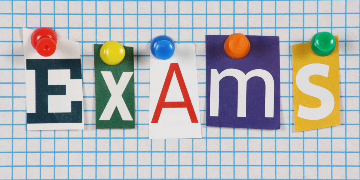 A sixth form student at a desk with A-Level past papers and revision notes spread out, preparing for January mocks