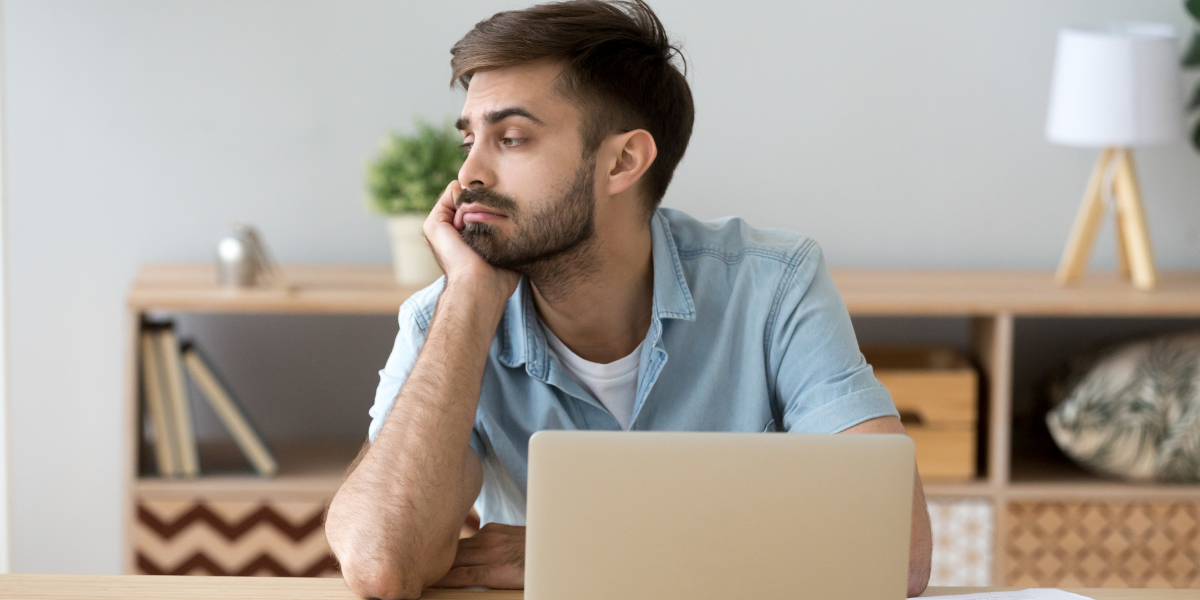 A student sitting at a desk looking out of a window, taking a moment before returning to revision notes