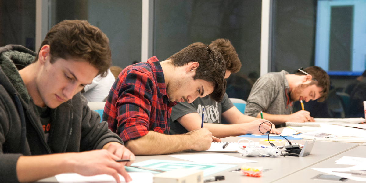 A sixth form student in a common room with A-Level textbooks open, settling into the new environment