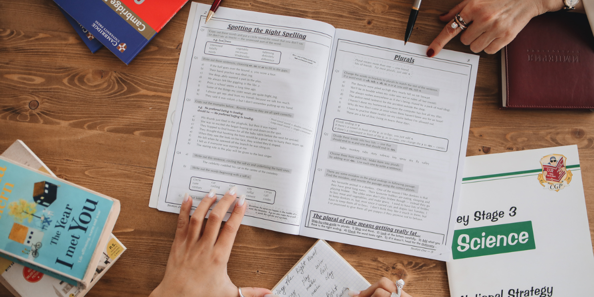 A student surrounded by different study materials including flashcards, diagrams, a notebook and headphones, representing different learning approaches
