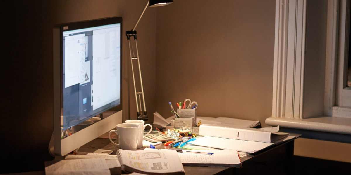 A Year 11 student studying at a tidy desk in the evening, looking focused but relaxed