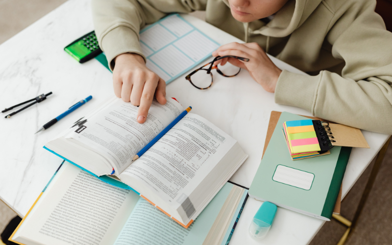 A student sitting at a desk independently working through revision notes and practice questions after a Learntit tuition session, applying what was covered in the lesson